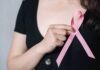 Woman holding a pink ribbon symbolizing breast cancer awareness – Breast Cancer: Importance of Self-Check
